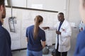 Engineer with apprentice at white board in front of group Royalty Free Stock Photo