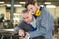 engineer and apprentice working on machine in factory Royalty Free Stock Photo