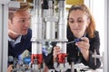 Engineer And Apprentice Working On Machine In Factory Royalty Free Stock Photo