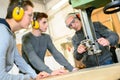 Engineer and apprentices using automated milling machine Royalty Free Stock Photo