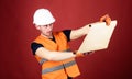 Engineer, architect, builder on strict face holds old blueprint in hands, supervises construction site. Foreman concept Royalty Free Stock Photo
