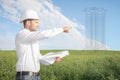 Engineer architect with drawings in white helmet shows construction site of future real estate object of apartment building. Royalty Free Stock Photo