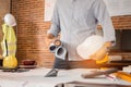 Engineer or Architect is holding blueprint with Safety helmet hard hat. Civil engineering, Architect concept Royalty Free Stock Photo