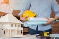 Engineer or Architect is holding blueprint with Safety helmet hard hat. Civil engineering, Architect concept Royalty Free Stock Photo