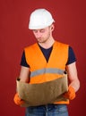 Engineer, architect, labourer, builder on strict face holds old blueprint in hands. Engineering concept. Man, handyman Royalty Free Stock Photo