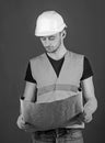 Engineer, architect, labourer, builder on strict face holds old blueprint in hands. Engineering concept. Man, handyman Royalty Free Stock Photo