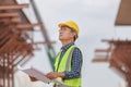 Engineer or architect man in hard hat holding a blueprint at construction site, Construction worker holding plan Royalty Free Stock Photo