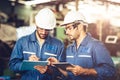 Engineer audit worker working team together with safety uniform and white helmet to work in industry factory handle tablet and Royalty Free Stock Photo