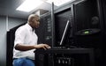 Engineer, black man or coding on laptop in server room for big data, network glitch or digital website. Code, IT support Royalty Free Stock Photo