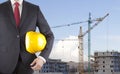 Engineer in black suit holding yellow helmet on construction site Royalty Free Stock Photo
