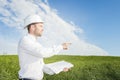 Engineer builder with drawings in his hands points to construction site of building. geologist on a green meadow in the afternoon Royalty Free Stock Photo
