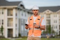 Engineer builder drinking take away coffee using phone on break. Builder at construction site. Buider with helmet on Royalty Free Stock Photo