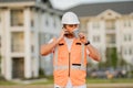 Engineer builder drinking take away coffee using phone on break. Builder at construction site. Buider with helmet on Royalty Free Stock Photo