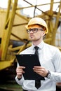 Engineer builder in a helmet holds folder at construction site Royalty Free Stock Photo