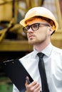 Engineer builder in a helmet holds folder at construction site Royalty Free Stock Photo