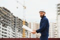 Engineer builder wearing safety vest with blueprint at construction site Royalty Free Stock Photo