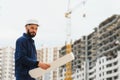 Engineer builder wearing safety vest with blueprint at construction site Royalty Free Stock Photo