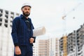 Engineer builder wearing safety vest with blueprint at construction site Royalty Free Stock Photo