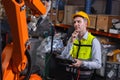 Engineer caucasion male working service fix operate automatic robot welding arm with question thinking solving problem expression