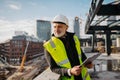 Engineer checking building documentation on clipboard at construction site. Royalty Free Stock Photo