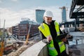 Engineer checking building documentation on clipboard at construction site. Royalty Free Stock Photo