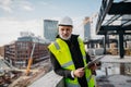 Engineer checking building documentation on clipboard at construction site. Royalty Free Stock Photo