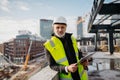 Engineer checking building documentation on clipboard at construction site. Royalty Free Stock Photo