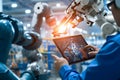 Engineer using tablet check and control automation robot arms machine in intelligent factory industrial Royalty Free Stock Photo