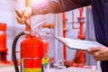 Engineer checking fire extinguisher. Royalty Free Stock Photo