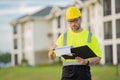 Engineer with clipboard, building inspection. Portrait of builder man. Construction worker with hardhat helmet on