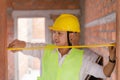 Engineer concept The constructing worker concentrating with measuring the width of the door with the yellow tape rule Royalty Free Stock Photo