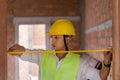Engineer concept The constructing worker concentrating with measuring the width of the door with the yellow tape rule Royalty Free Stock Photo