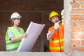 Engineer concept The female constructor holding the building scheme while the constructing guy scaling the surface of the building