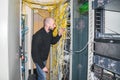 The engineer connects the optical wire to the central router. The system administrator works in the server room of the data center