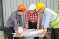 Engineer and construction team looking at blueprint and talk about construction process . Royalty Free Stock Photo