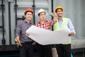 Engineer and construction team wearing safety helmet and blueprint on hand. they are checking progress of construction site. Royalty Free Stock Photo