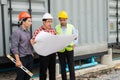 Engineer and construction team wearing safety helmet and blueprint on hand. they are working on checking progress of construction Royalty Free Stock Photo