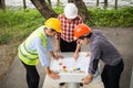 Engineer and construction team wearing safety helmet and looking blueprint on the table at construction site. Royalty Free Stock Photo