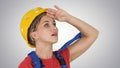 Engineer construction worker woman fascinated by the scale of construction on gradient background. Royalty Free Stock Photo