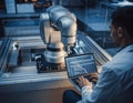 Robotics Engineer Programming Industrial Arm in Modern Lab Royalty Free Stock Photo