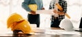 Engineer desk with object paper and tablet with blurry engineer teamwork hardworking to consults about their building project