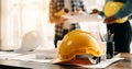 Engineer desk with object paper and tablet with blurry engineer teamwork hardworking to consults about their building project