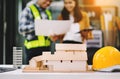 Engineer desk with object paper and tablet with blurry engineer teamwork hardworking to consults about their building project