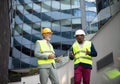 Engineer discussing the structure of the building with architects colleague at construction site Royalty Free Stock Photo