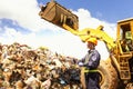 Engineer driving a loader in the recycling plant. Factory recycle workers are using a tablet to control work in the recycling Royalty Free Stock Photo