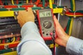 Engineer electric measures voltage with multimeter close-up. professional electrician measures voltage with tester Royalty Free Stock Photo