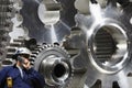 Engineer examining large gears and cog machinery