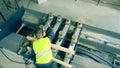 Engineer is examining wooden balks processed by the machine