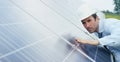 Engineer expert in solar energy photovoltaic panels with remote control performs routine actions for system monitoring using clean Royalty Free Stock Photo