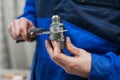 Close-up of the hand of a worker measuring a part from the mechanism of an accurate measuring instrument. Electronic caliper Royalty Free Stock Photo